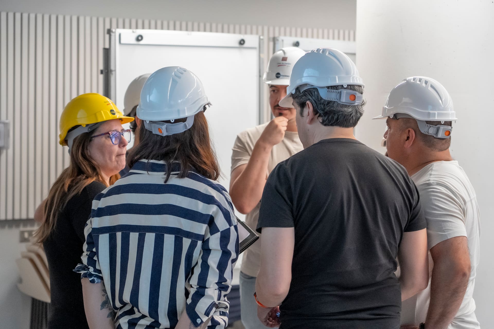Manos de participantes armando el puente durante el taller COMBRIDGE